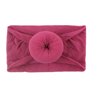 Détail d'un bandeau large en nylon rose vif avec nœud en forme de beignet doux pour bébé