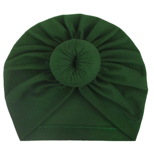 Detailed close-up of dark green baby turban hat with donut knot and knit texture