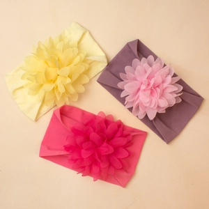 Detailed view of three elastic nylon headbands with large layered chiffon floral designs
