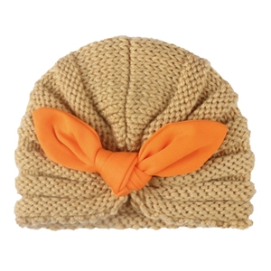 Warm beige knitted baby hat with orange bunny ear bow, winter head wrap for infants