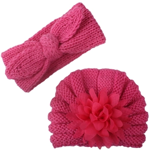 Detail of rose red knit baby hat with layered fabric flower and matching headband