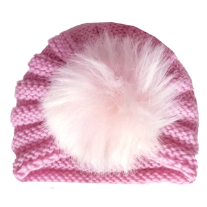 Pink knitted baby winter hat with large fluffy pom-pom and warm ear protection design