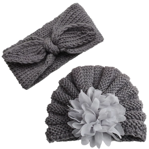 Detailed knit texture of grey baby hat with flower and matching bow headband set