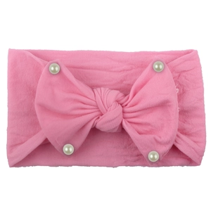 Detail of pink nylon baby headband with ribbed texture, large bow and white pearls