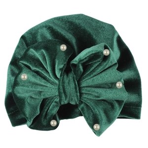 Detailed view of dark green velvet baby turban hat with bow and white pearl accents
