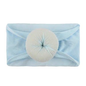 Détail d'un bandeau bébé bleu clair en nylon souple avec un ornement rond en tissu