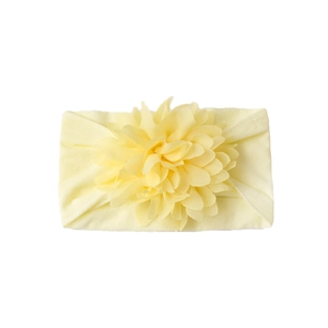 Detailed close-up of pale yellow baby nylon headband with large layered petal flower ornament