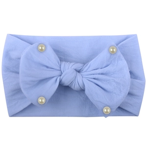Detail of light blue baby headband featuring a large bow and decorative white pearls