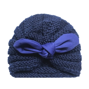 Detailed knit texture of dark blue baby turban hat with a large decorative bow