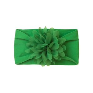 Detail of baby headband with a large layered green fabric flower and elastic nylon band