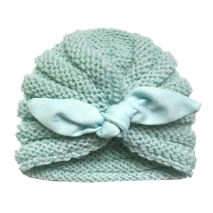 Close-up of baby knit hat featuring soft mint green texture and a cute rabbit ear knot