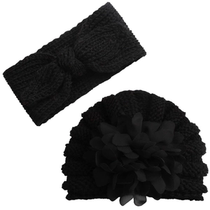 Detail of black knit baby set showing thick bow headband and flower beanie