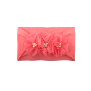 Detalle de diadema para bebé rosa coral con tres flores de gasa y adornos de cuentas