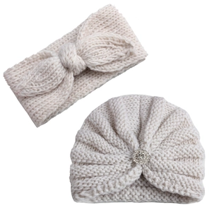 Détail du turban pour bébé en maille crème avec boucle strass et bandeau à nœud assorti