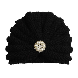 Black knit turban baby hat featuring a central pearl and rhinestone flower brooch