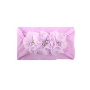 Detalle de diadema para bebé con flores de gasa lavanda, perlas y pedrería brillante