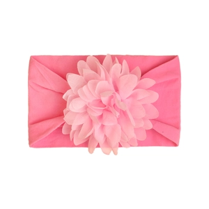 Detail of baby headband with a large layered light pink chiffon flower on elastic nylon band