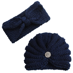 Détail d'un bandeau en tricot bleu marine avec nœud et d'un bonnet à strass assorti