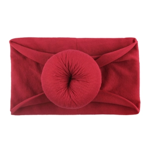 Détail d'un bandeau en nylon bordeaux avec un nœud donut souple pour les bébés