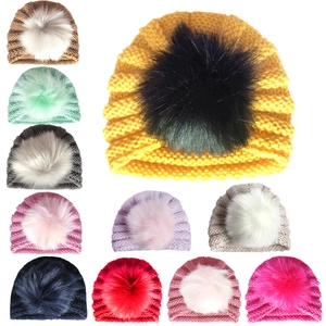 Winter baby knit beanie with large faux fur pompom shown in various vibrant colors