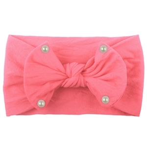 Detail of soft nylon baby headband with pink bow and pearl accents for infants