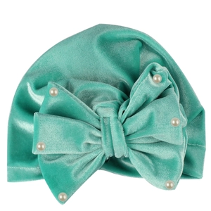 Close-up of velvet baby turban with large mint green bow and delicate pearl beads