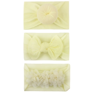 Detailed view of three soft nylon baby headbands in light yellow with bow and floral knots