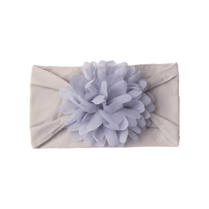 Detail showing a soft grey nylon baby headband with a large purple chiffon flower deco