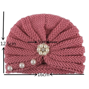 Pink knit baby turban hat featuring white faux pearl accents and dimension measurements