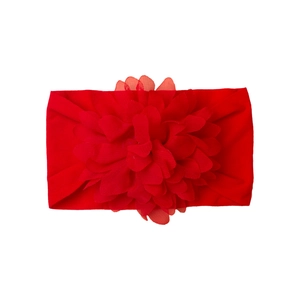 Detailed close-up of vibrant red elastic baby headband with large layered tulle flower