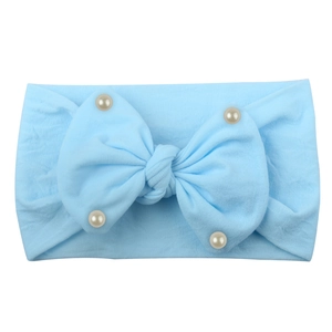 Detail of soft sky blue nylon baby headband with a large bow and elegant faux pearls