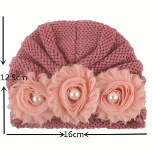 Detail of baby knit hat with pink chiffon flowers and pearl beads showing size measurement