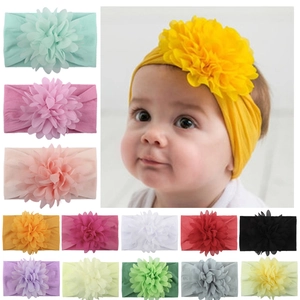 Détail montrant diverses couleurs de bandeaux à fleurs en nylon pour bébé fille à plat