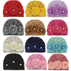 Detailed catalog showing twelve colors of baby knit turbans with pearl flower accents