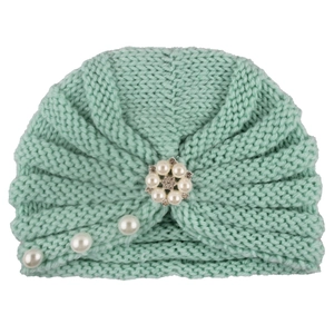 Close-up of mint green knitted baby turban hat with elegant pearl and rhinestone flower detail