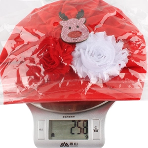 Detailed view of red Christmas baby turban hat showing weight of 25.8g on a digital scale