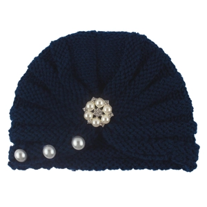 Detailed knit texture of navy blue baby turban hat with elegant faux pearl floral ornament
