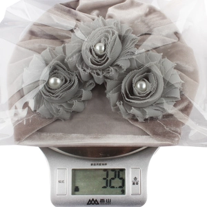 Detail of velvet baby turban hat with decorative fabric flowers weighing 32.5g