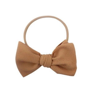 Newborn ginger yellow nylon headband featuring a large ribbed bow decoration
