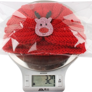 Détail du bonnet de Noël rouge pour enfant avec cerf pesant 32,7g sur la balance