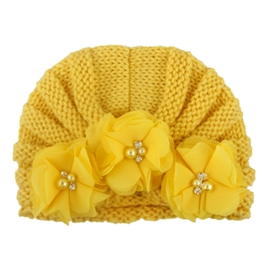 Detail of yellow knit baby turban hat with chiffon flowers, pearls and rhinestones