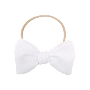 Infant nylon headband with a white waffle-textured bow and nude stretchy elastic strap