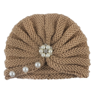 Close-up of khaki knitted baby turban hat with pearls, rhinestones and floral detail