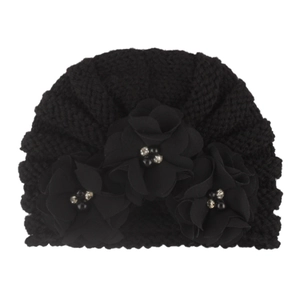 Detail of baby knitted hat with three black fabric flowers and beaded centers