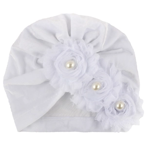 Detailed macro view of white baby turban featuring fabric flowers and faux pearl centers
