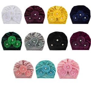 Detailed grid of baby velvet turbans with layered fabric flowers and pearl accents