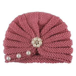 Detail view of pink knit baby turban hat featuring faux pearl and rhinestone floral accent