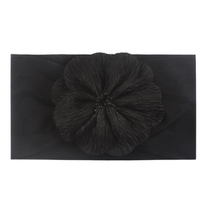 Gros plan du bandeau bébé noir en nylon avec une grande fleur plissée élégante et souple