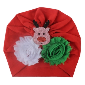Detailed view of red Christmas baby turban with reindeer mascot and festive floral accents