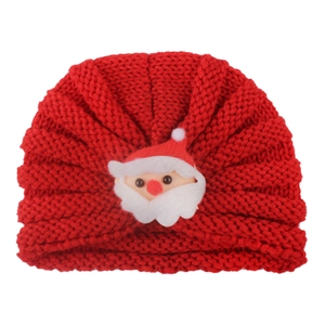 Dettaglio cappello natalizio lavorato a maglia per neonati con decoro Babbo Natale 3D